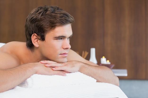 Man lying on massage table at spa center