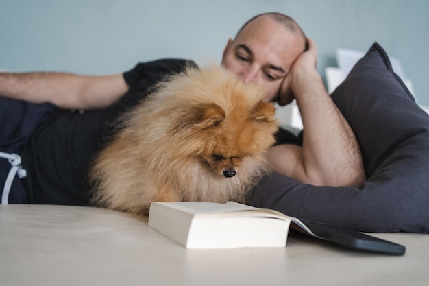 Photo man lying with dog on sofa