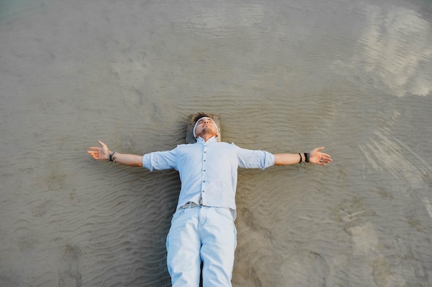 Photo man lying on wooden bridge against the background of the water