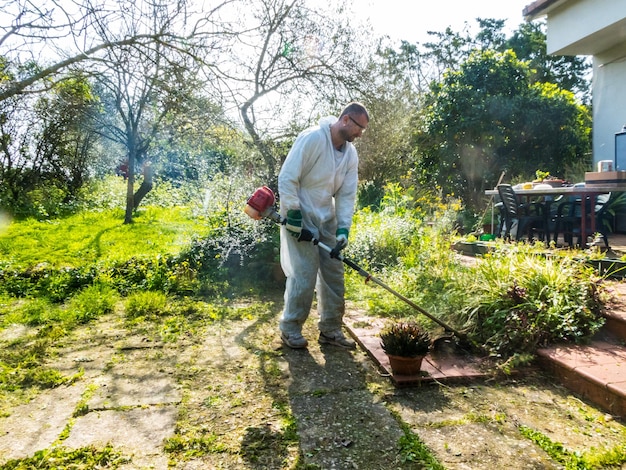 Man maait gras het gras in de tuin