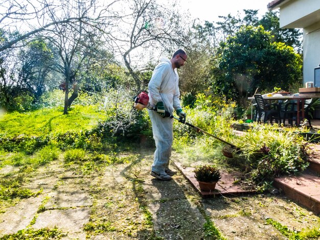 Man maait gras het gras in de tuin