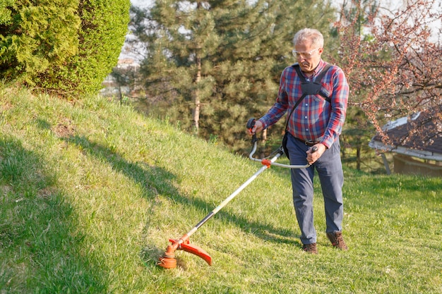 Man maait het gras met een grasmaaier.