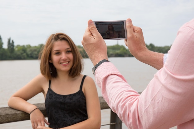 Man maakt foto's met zijn mobiel van een vrouw