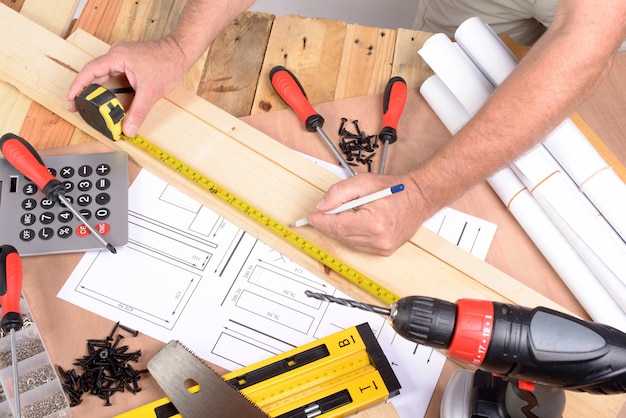 man made a piece of furniture with various carpentry tools