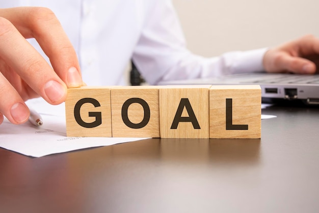 Man made word goal with wood blocks on the background of the office table selective focus business concept