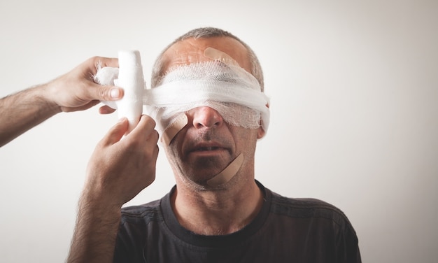 Man makes bandage in injured man. Trauma of the head