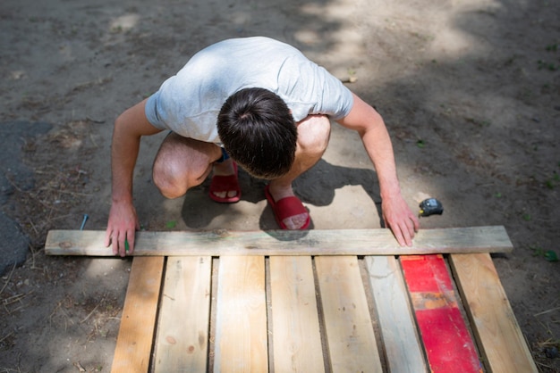 Photo a man makes markings on wooden planks