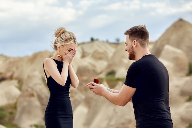 Man makes a marriage proposal to his girlfriend. Engagement of a couple in love in nature. The guy wears a wedding ring on a woman's finger. Happy emotions on your face. Turkey, Cappadocia, 9 may 2018