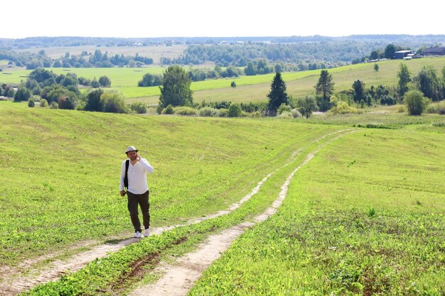 A man makes a tourist trip to the village Flooded fields meadows a country road a sunny day and a walk in the fresh air