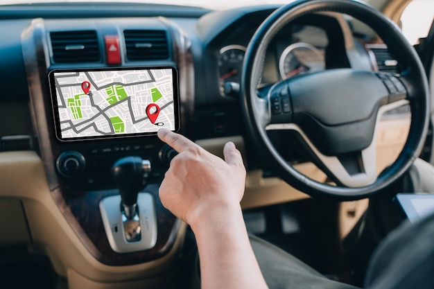 Un uomo utilizza il gps e la mappa online di internet nell'auto controlla il navigatore per il tracciamento gps