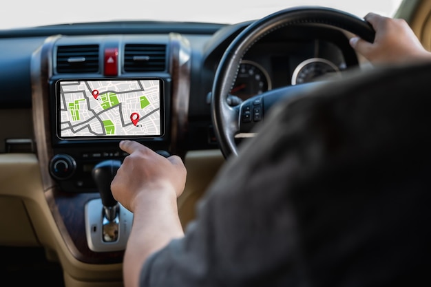 A man makes use of GPS and the internet online map in the car controls the navigator for GPS tracking