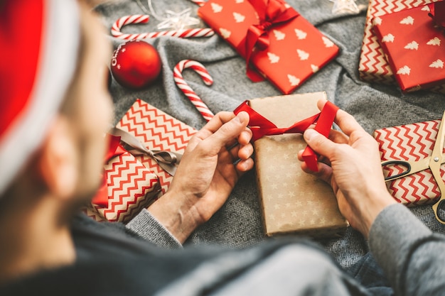 Foto uomo che fa arco da nastro sul regalo