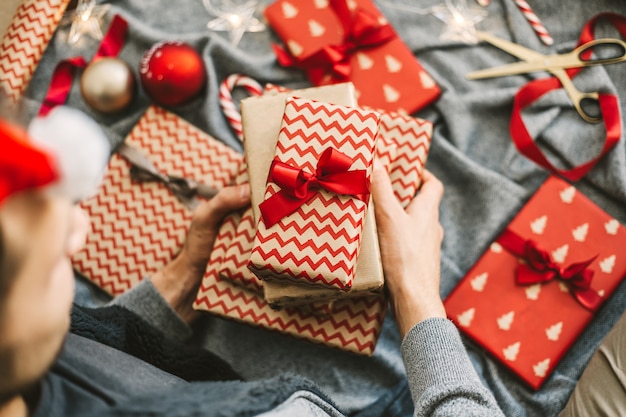 Man making bow from ribbon on gift