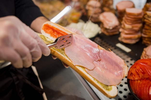 A man making ham sandwich toast and sauce