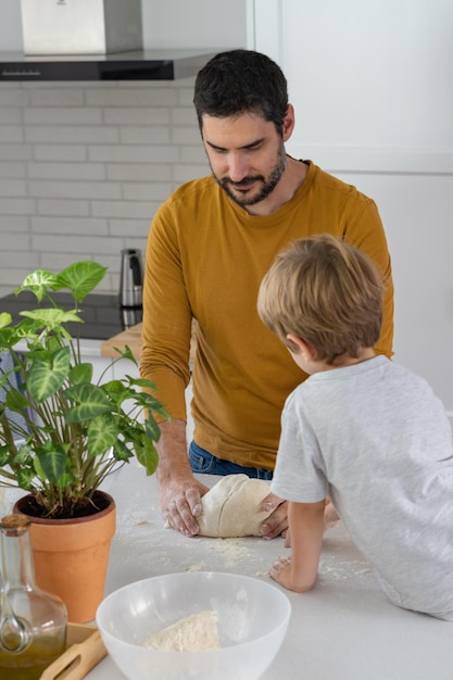 Man making homemade bread with his son