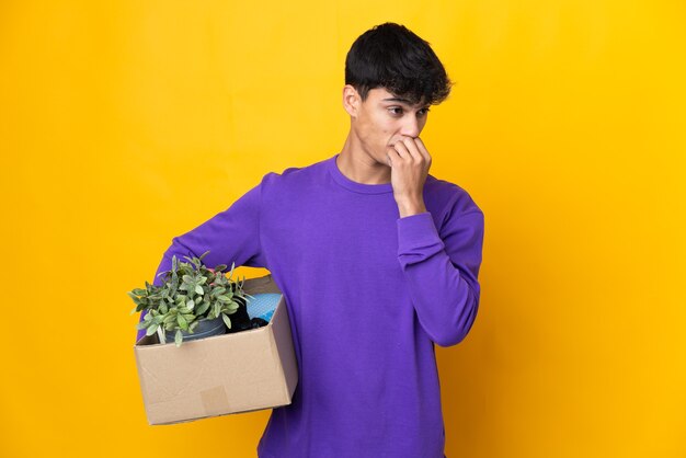 Man making a move while picking up a box full of things having doubts