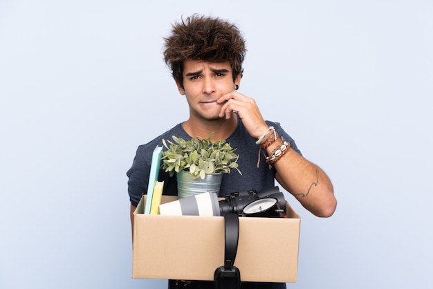 Man making a move while picking up a box full of things nervous and scared