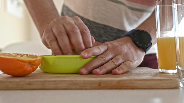 Man making orange juice at kitchen