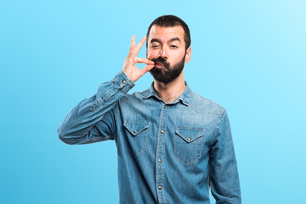 Photo man making silence gesture on colorful background
