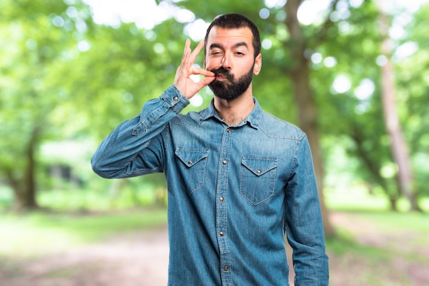 Photo man making silence gesture on unfocused background