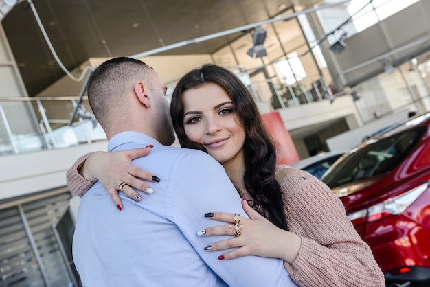 Photo man making surprise for his wife in avto salon