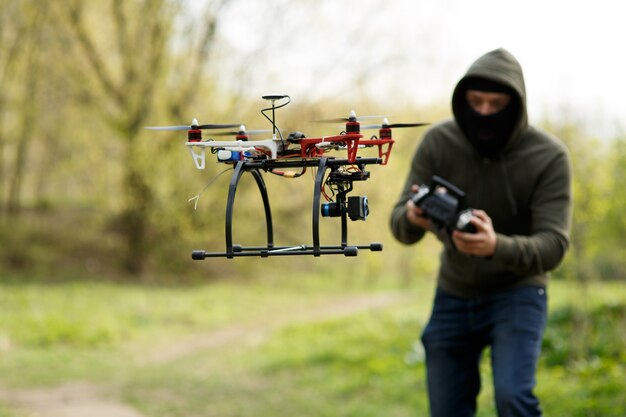 Man in mask flying with the drone. Technology thief concept