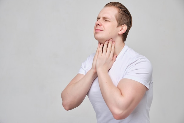 man massages his neck in pain.