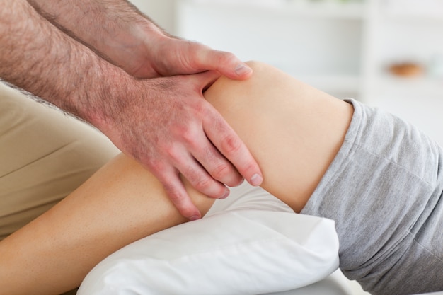 Photo man massaging a woman's knee