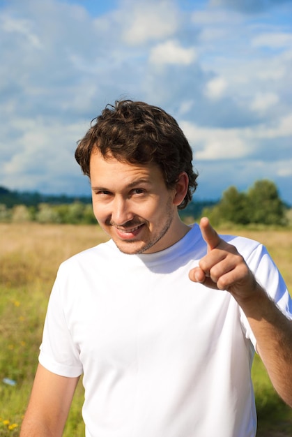 Man in the meadow pointing the finger