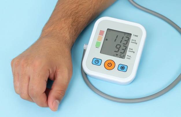 Man measures his blood pressure by electronic tonometer close-up