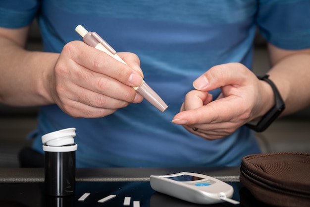 L'uomo misura il suo concetto di diabete del test del campione di sangue del glucometro