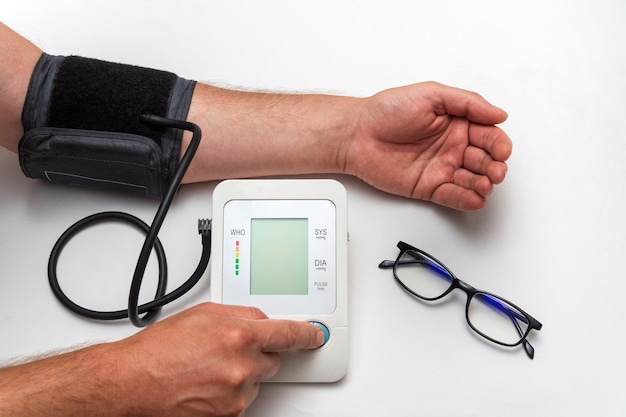 A man measures his own blood pressure on a medical table Taking care of your own health