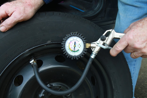 man measuring tire pressure