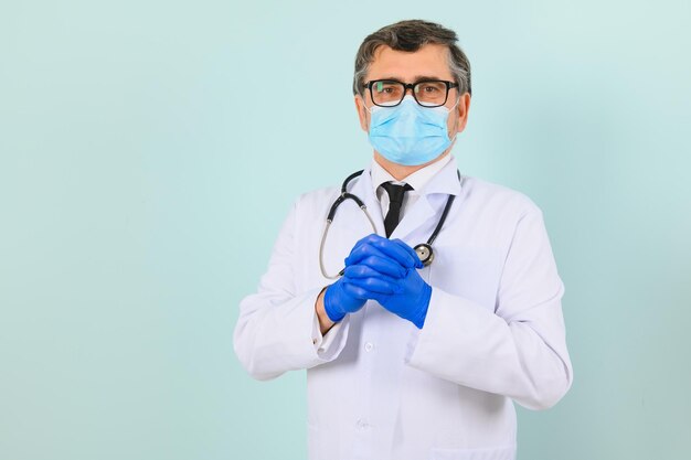 Человек в медицинских перчатках и защитной маске на синем фоне
