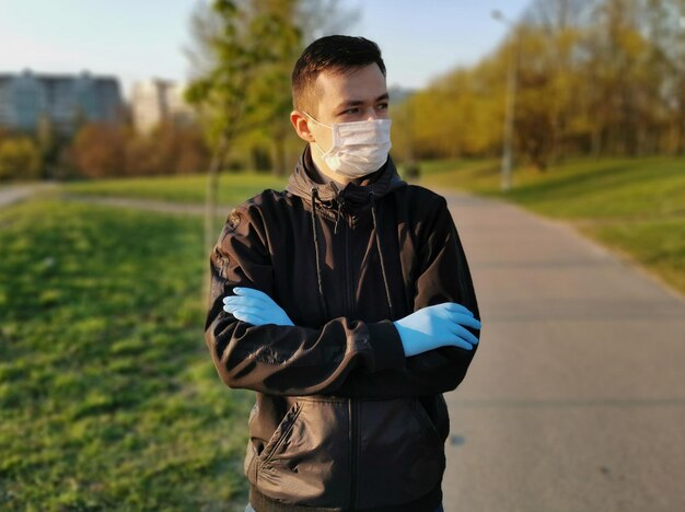 A man in a medical mask and gloves on the street in spring Coronavirus Protection 2020