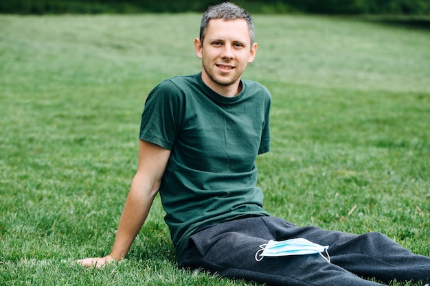 Man in a medical mask on the grass