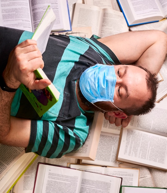 Man in medical mask with lots of paper books