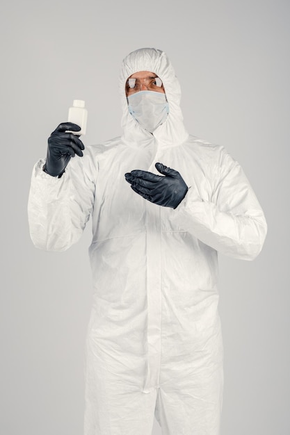 A man in a medical protective mask holding a hand sanitizer