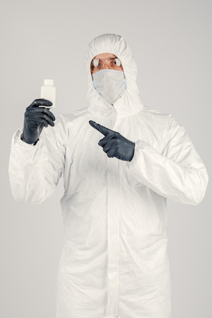 A man in a medical protective mask holding a hand sanitizer