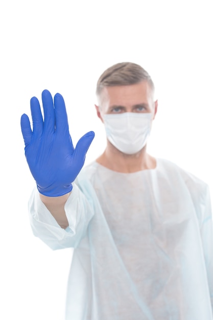 Man medical worker epidemiologist stop covid19 showing gesture with hand in glove wear respirator m