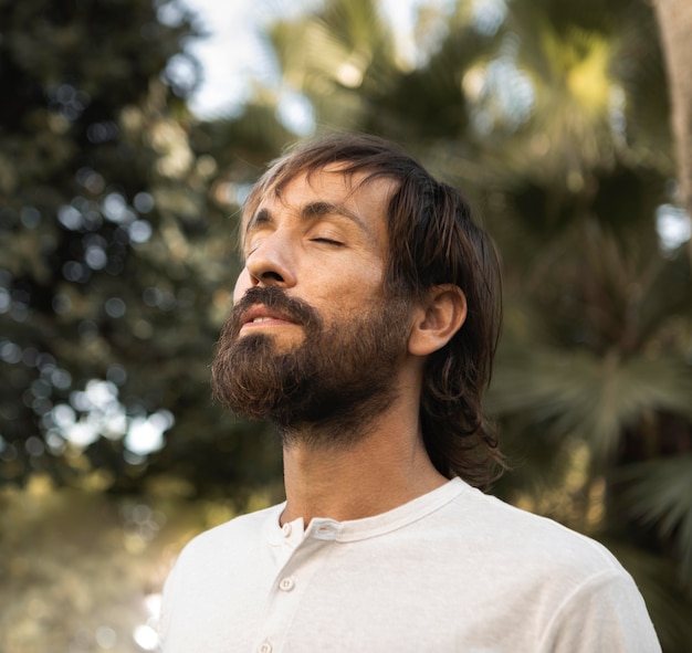 Foto uomo che medita all'aperto mentre si fa yoga