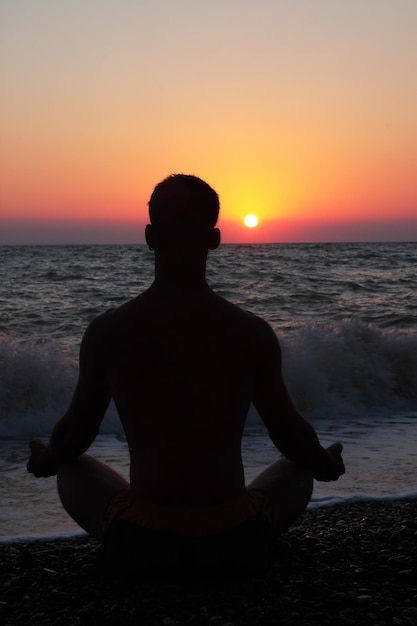 海の岸で瞑想中の男