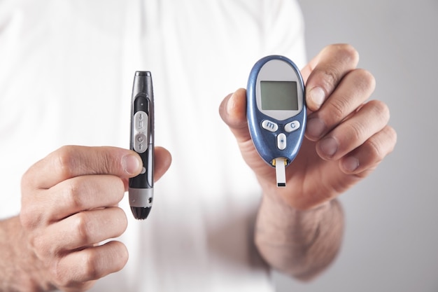 Man met apparaten voor het meten van glucose in het bloed.