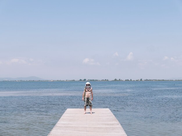 Man met astronautenhelm op het strand