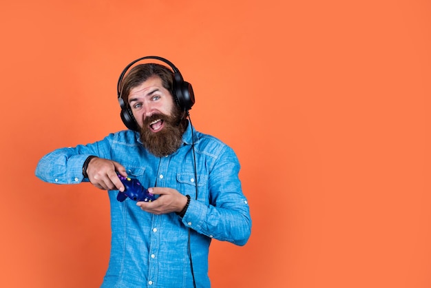 Man met baard die videospelletjes speelt brutale Kaukasische hipster met snor ontspannen thuis console controller joystick gamen in oortelefoons kopieer ruimte volwassen man gamer speel computerspelletjes