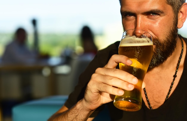 Man met baard drink bier bier tijd brutale hipster bebaarde man zit aan toog knappe barman ho