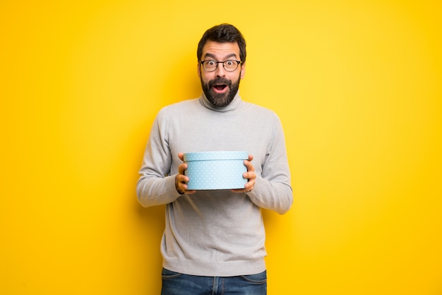 Man met baard en coltrui verrast omdat een geschenk is gegeven