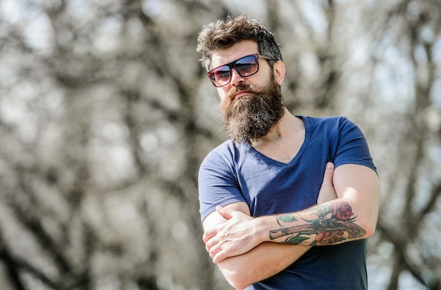 Man met baard met zonnebril natuur achtergrond Bebaarde hipster brutale man draagt beschermende zonnebril Hipster zelfverzekerd in donkere zonnebril Bebaarde man draagt moderne modieuze zonnebril UV-filter