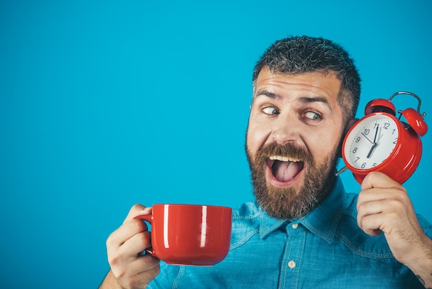 Man met baard op blij gezicht met beker, wekker