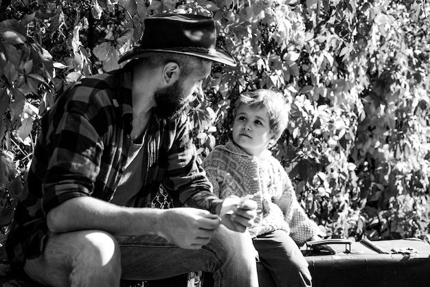 Man met baard, vader met jonge zoon in herfstpark Kid en zijn vader zijn in herfstpark